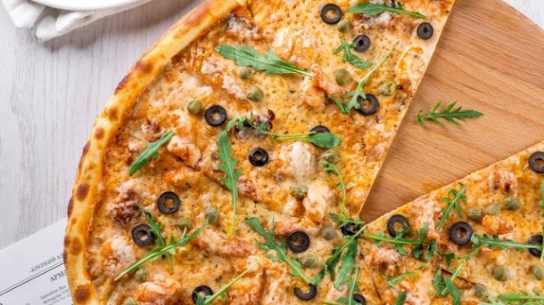 gambar pizza panggang dengan topping daging dan sayur diatasnya